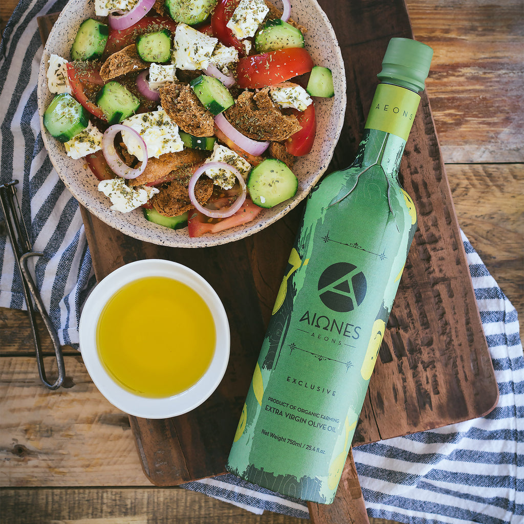 Olive oil bottle with a salad and olive oil on a wooden surface