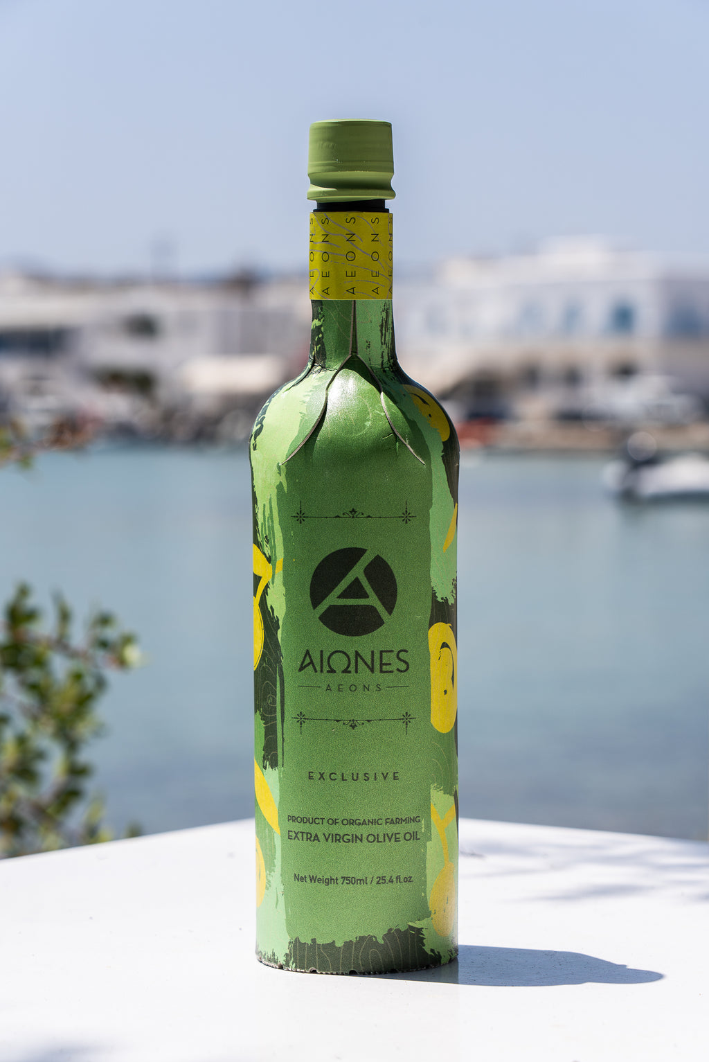 Green bottle of Aiones olive oil with a scenic background