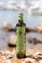 Bottle of AEONS Organic Extra Virgin Olive Oil on a rocky surface with water in the background